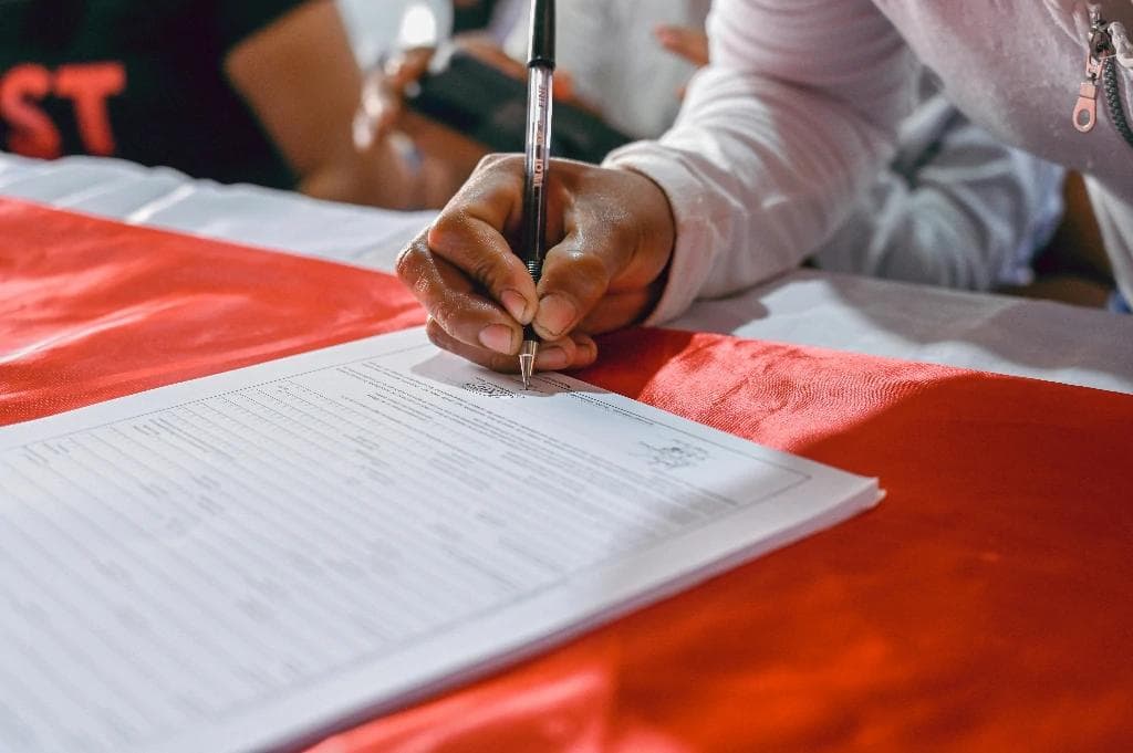 Photo of a woman signing a document